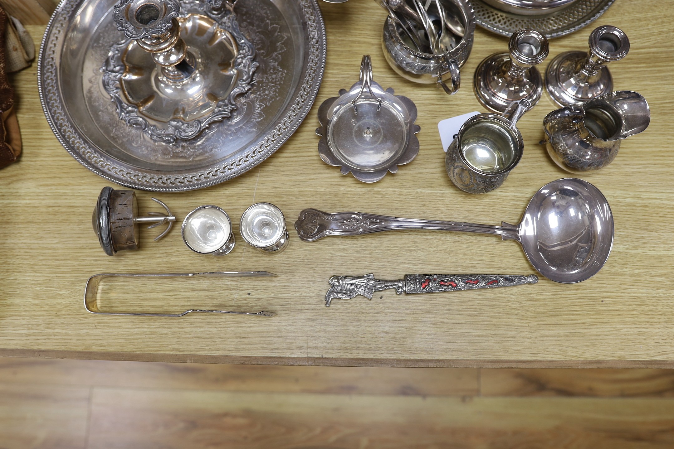A quantity of assorted plated wares including a chamberstick, a tea set, flatware, a cocktail shaker, a sauceboat, goblets, etc.